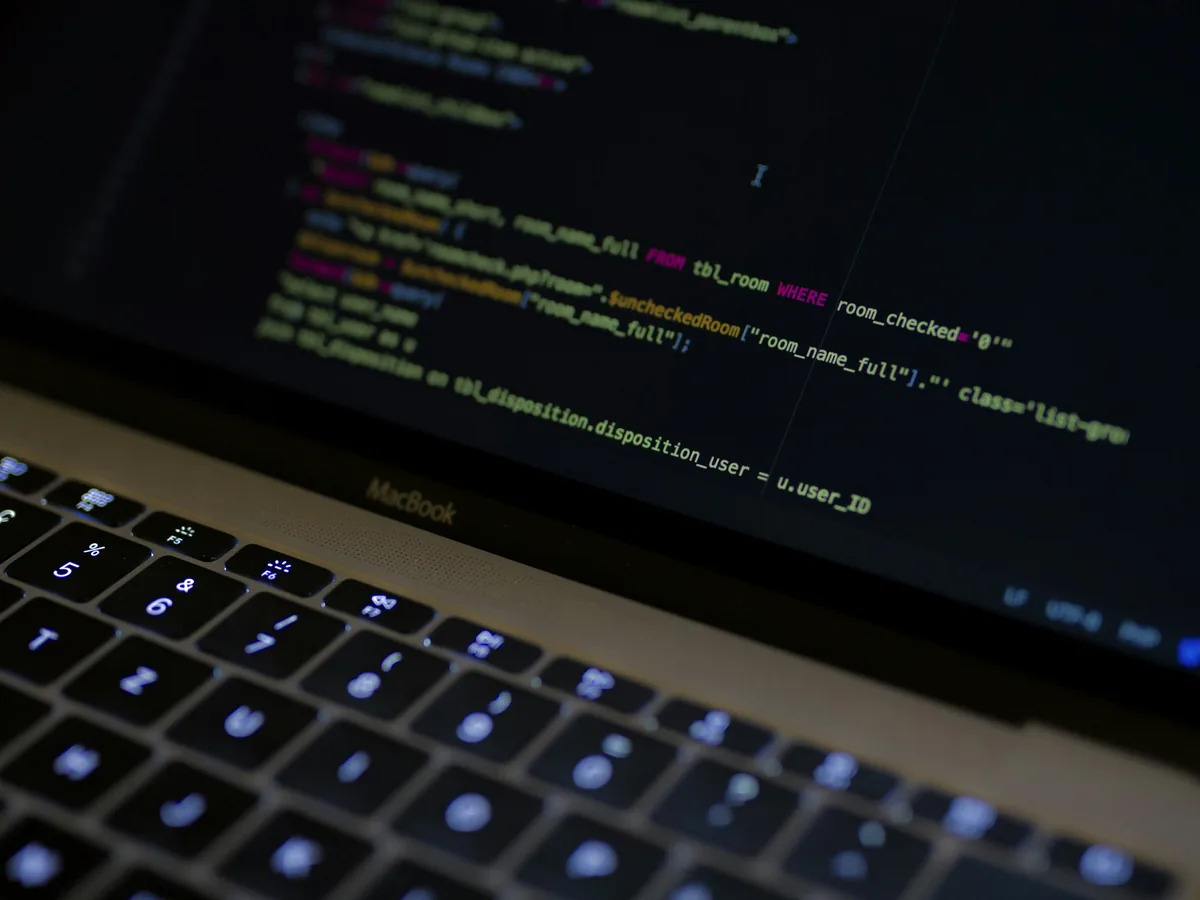 Application code on a laptop screen in a dark workspace
